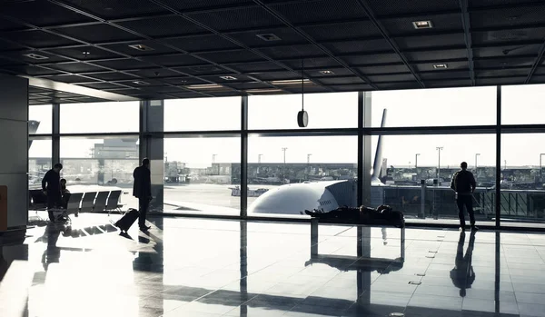 Τουριστική επιβάτες με βαλίτσα, αποσκευές στην αίθουσα σαλόνι. Άνθρωποι περιμένουν για πτήση στο αεροδρόμιο στο μεγάλο παράθυρο γυαλιού. Περιπλάνησης, διακοπές, ταξίδια. — Φωτογραφία Αρχείου