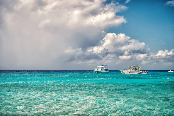 Grand Turk, Islas Turcas y Caicos - 29 de diciembre de 2015: barcos de motor en mar turquesa en el cielo nublado. Barcos en idílico paisaje marino. Aventura acuática y viajes. Vacaciones de verano en isla tropical —  Fotos de Stock