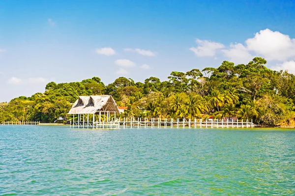 在危地马拉的热带海滩上的木材和草的房子, 圣托马斯。在阳光明媚的蓝天上的海滨小屋。在岛上的暑假。流浪, 探险和发现 — 图库照片