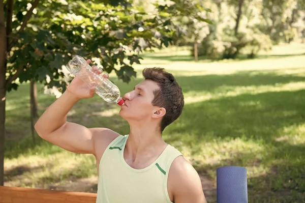 Sportsman boire de l'eau dans le parc par une journée ensoleillée — Photo