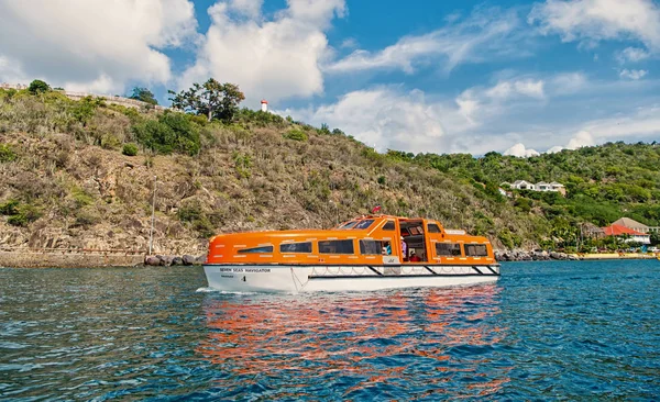 Gustavia, St.barts - 25 de novembro de 2015: viagem de navio em mar azul ao longo da costa. Transporte de água e embarcação. Viajar no mar, vaguear. Férias de verão na ilha tropical — Fotografia de Stock