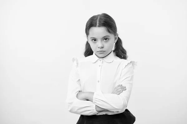 Desacuerdo y terquedad. Chica escuela uniforme serio cara ofendido fondo amarillo. El chico infeliz se ve estrictamente. La chica con los brazos cruzados en el pecho parece seria. Chica sensible no quiere hablar — Foto de Stock