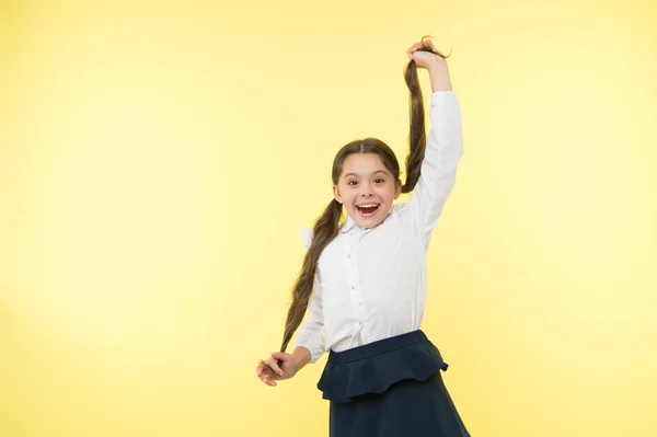 Bequeme und einfache Frisur. Umgang mit Langhaarfrisuren selbst. Mädchen langen Pferdeschwanz Frisur. Kinderschuluniform frisiert. Kinder stylische modische Pose halten Pferdeschwänze Frisur — Stockfoto