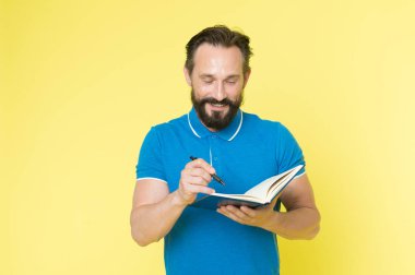 Yardımcı kontrol listesi. Yetişkin sakallı bir adam not defterine notlar yazıyor. Ne yapıldığına bak. Günlük program. Alışkanlıklar geliştirmek ve rutin şeyler yapmak. Görevlerin kontrol listesi. Yapılacak ve yapılacak günlük kontrol listesi