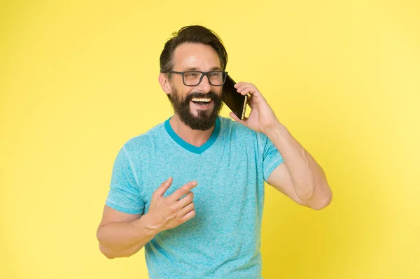 Залишайся на зв'язку. Чоловік бородатий веселий зрілий хлопець тримає мобільний телефон жовтим тлом. Партнер виклику смартфона Hipster. Чоловік мобільний телефонний смартфон. Концепція мобільного дзвінка. Важлива мобільна розмова — стокове фото