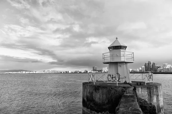 reykjavik lighthouse tower on stone pier in iceland. lighthouse in sea. architecture in seascape and skyline. navigational aid and destination places. wanderlust and travelling to reykjavik, iceland.