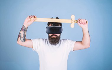 Oyun kavramı. Vr gözlük, açık mavi renkli sakallı adam. Adam kafa monte görüntü tutar kılıç, Vr. Hipster oyunda ciddi yüz mücadele oyun ile zevk oyna sanal gerçeklik