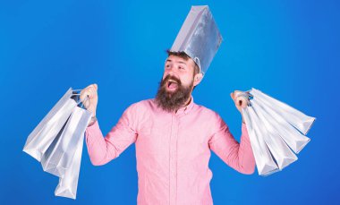 Şık sakal ve güler yüz üzerinde mavi arka plan izole olan adam. Pembe gömlekli alışveriş, satış konsepti yapıyor trendy sakallı hippi. Kağıt torba taşıyan ve sevinç bağırarak mutlu sakallı adam