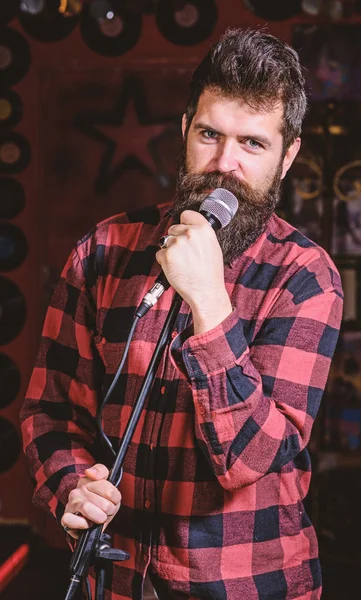 Man with calm face holds microphone, singing song, black background. Guy  likes to sing rock songs. Musician with beard and mustache singing song in  karaoke. Vocalist concept - Stock Image - Everypixel