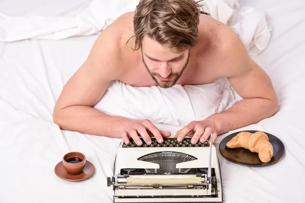 Man writer lay bed with breakfast working. Morning bring fresh idea. Morning inspiration. Erotic literature. Daily routine of writer. Writer handsome author used old fashioned manual typewriter