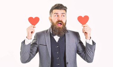 Sevgililer günü kavramı. Beyaz zemin üzerine kırmızı kalp ayakta veren resmi kıyafetli yakışıklı adam