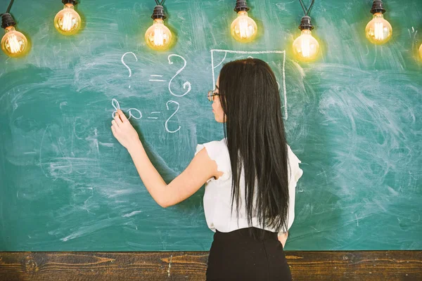 Καθηγήτρια μαθηματικών, γράφοντας στον πίνακα κιμωλίας, πίσω όψη. Δάσκαλος σέξι κυρία γυαλιά εξηγώντας φόρμουλα. Σέξι δασκάλα έννοια. Γυναίκα με μακριά μαύρα μαλλιά της διδασκαλίας των μαθηματικών στο σχολείο — Φωτογραφία Αρχείου