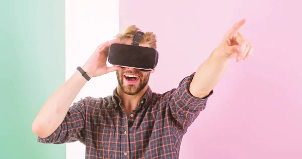 Man unshaven guy VR glasses enjoy visiting concert, pink background. Hipster use modern technologies for entertainment. VR event concept. Guy VR glasses head mounted display enjoy virtual concert