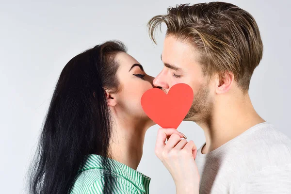Romantic kiss concept. Couple in love kissing and hide lips behind heart card. Celebrate valentines day. Sensual kiss of lovely couple close up. Man and woman romantic kiss. Love and foreplay — Stock Photo, Image
