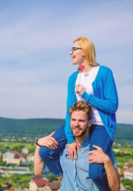 Pastoral Tarih kavramı. Adam kız arkadaşı omuzlarında, gökyüzü arka plan taşır. Aşık çift mükemmel tarih güneşli günler. Çift mutlu Tarih birlikte eğleniyor. Kadın zevk mükemmel romantik tarih