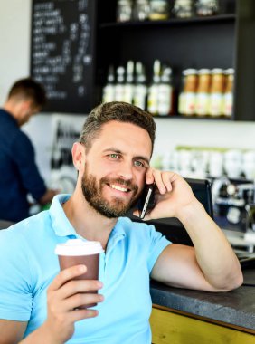 Adam akıllı telefon sipariş kafede kahve. Kahve molası kavramı. Kahve meşgul insanlar için seçenek götürün. Adam telefon konuşma kafe barista arka plan. Beklerken kahve içmek. Seni bekliyor