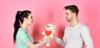 Adam ve kadın çift aşık kalp Sevgililer kartları ve ayıcık pembe arka plan üzerinde tutun. Romantik Çift aşık. Sevgililer günü ve aşk. Sevimli Hediyelik konsepti. Yakışıklı adam ve aşık güzel kız.
