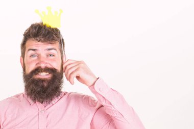 Fotoğraf booth eğlence kavramı. Kağıt parti sahne taç, beyaz arka plan tutan adam. Hippi photo booth sahne, kopya alanı ile poz neşeli yüzünde bıyık ve sakal ile. Kağıt taç kral