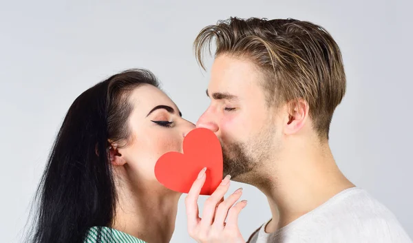 Baiser sensuel d'un couple charmant de près. Embrasse romantique homme et femme. Amour et préliminaires. Concept de baiser romantique. Couple amoureux embrasser et cacher les lèvres derrière la carte cardiaque. Célébrez la Saint Valentin — Photo