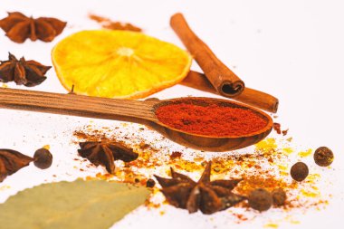 Baharat seti hazırlamak için mulled şarap ya da sıcak içecek, yakın çekim. Sıcak içecekler baharat seti. Baharat Seti kavramı. Kaşık ile baharat, kurutulmuş portakal, tarçın, kakule ve beyaz zemin üzerine Hindistan cevizi