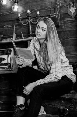 Kız öğrenci çalışma kitabı içinde hakem ev ile. Bayan kareli giysiler içinde sakin yüzünde sevimli ve rahat görünüyor. Ahşap vintage iç kitap ile gündelik kıyafeti kız oturuyor. Çalışma kavramı