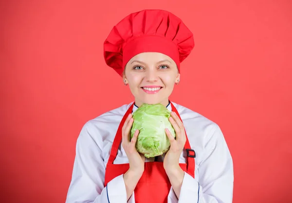 Healthy nutrition. Woman professional chef hold whole cabbage vegetable. Healthy vegetarian recipe ingredient. Healthy raw food. Dieting concept. Eat healthy. Girl wear hat and apron hold vegetable