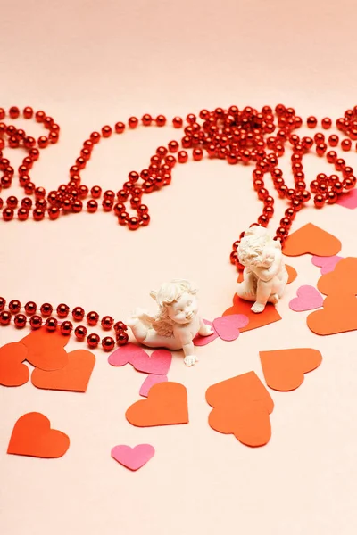 Cupidi in gesso con cuori e perline rosse, concetto di amore — Foto Stock
