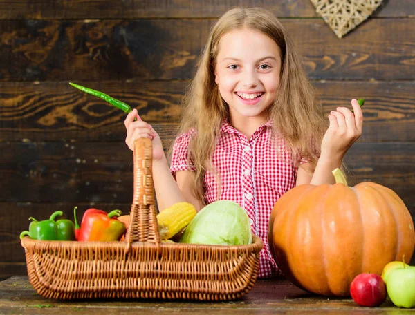 Niña niña disfrutar de la vida en la granja. Jardinería orgánica. Niño agricultor con fondo de madera de la cosecha. Cultiva tu propia comida orgánica. Niña en el mercado agrícola con verduras orgánicas. Concepto del festival Harvest — Foto de Stock