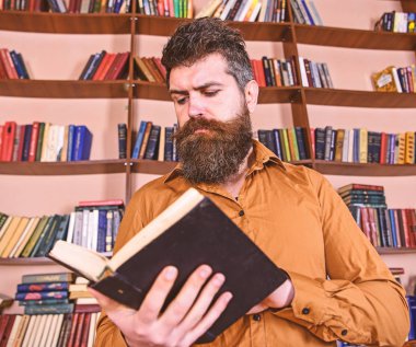 Adam meşgul düşünceli yüz kitap okumak, kitap rafı arka plan üzerinde. Öğretmen ya da sakal Kitaplığı'nda eğitim ile öğrenci. Bilim adamı kitap keşfetmek ile meşgul. Eğitim ve bilim kavramı