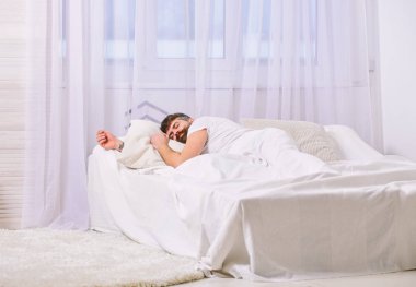 Sakin yüz beyaz çarşafımda yatıyor adam, yastık. Adam arka plan üzerinde battaniye, beyaz perdeler ile kaplı yatağa atma. Maço sakal uyku ile rahatlatıcı, nap, sahip rest. NAP ve siesta kavramı.