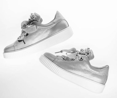 Ayakkabı kız ve kadınlar için inci boncuklar ile dekore edilmiştir. Son moda spor ayakkabı kavramı. Kadife kurdela ile soluk pembe kadın spor ayakkabı çifti. Şirin ayakkabılar beyaz arka plan üzerinde üstten görünüm izole