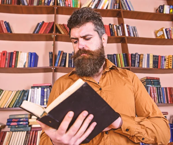 Adam meşgul düşünceli yüz kitap okumak, kitap rafı arka plan üzerinde. Öğretmen ya da sakal Kitaplığı'nda eğitim ile öğrenci. Bilim adamı kitap keşfetmek ile meşgul. Eğitim ve bilim kavramı