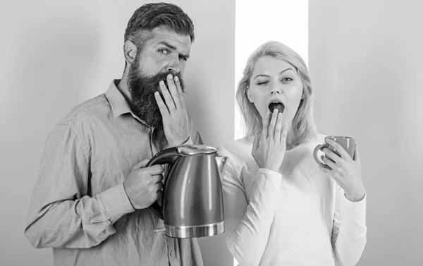 Lo primero que hacen cada mañana es preparar una bebida caliente. Obtener carga de energía bebida caliente favorita. Disfrutando de una buena mañana juntos. Hombre con hervidor eléctrico y mujer con taza listo para beber café de la mañana —  Fotos de Stock