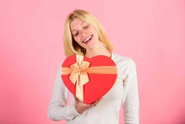 Frau hält herzförmigen Geschenkkarton. Aufgeregt über das Geschenk zum Valentinstag. Am Valentinstag würde sich jedes Mädchen freuen. romantisches Überraschungsgeschenk für sie. herzzerreißende Valentinstagsgeschenke, die sich jedes Mädchen wünscht — Stockfoto