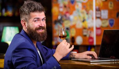Hipster freelancer iş online içme konyak. Adam işadamı bar counter dizüstü konyak sakallı. Çok iyi başarılı işadamı sakin ol. Başarı kutlamak. İşadamı Internet sörf içki alkol