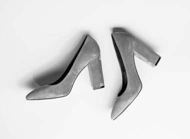 Suede footwear concept. Pair of fashionable high heeled shoes. Shoes made out of grey suede on yellow background. Footwear for women with thick high heels, top view clipart