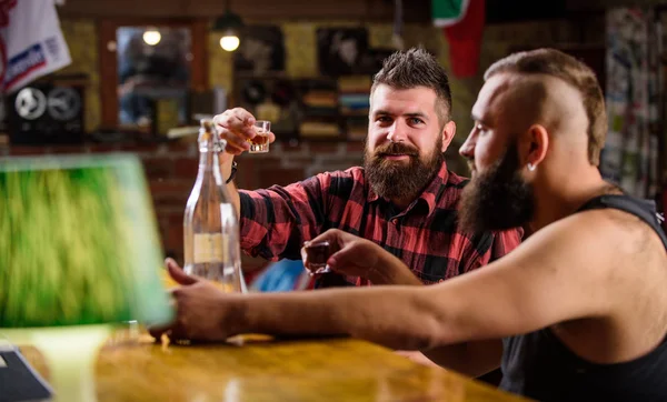 Men drinking alcohol together. Strong alcohol drinks. Friends relaxing in pub. Alcohol addiction. Men drunk relaxing at pub having fun. Hipster brutal man drinking alcohol with friend at bar counter