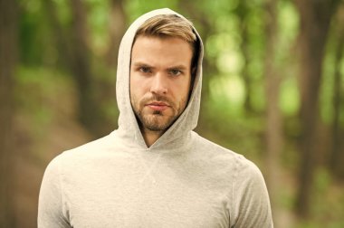 Adam sakallı ve çekici görünüşü hakkında umurunda değil. Ciddi yüz, Doğa arka plan, defocused kıl olan adam. Cilt bakım kavramı. Sakal veya tıraşsız adam görünüyor yakışıklı Kapşonlu adamla.