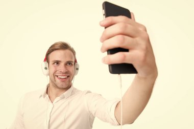 Müzik her zaman benimle. Adam kulaklık ile müzik dinler. Adam mutlu dinleme favori şarkı kulaklık ile smartphone. Adam güler yüz zevk müzik dinleme izole beyaz arka plan