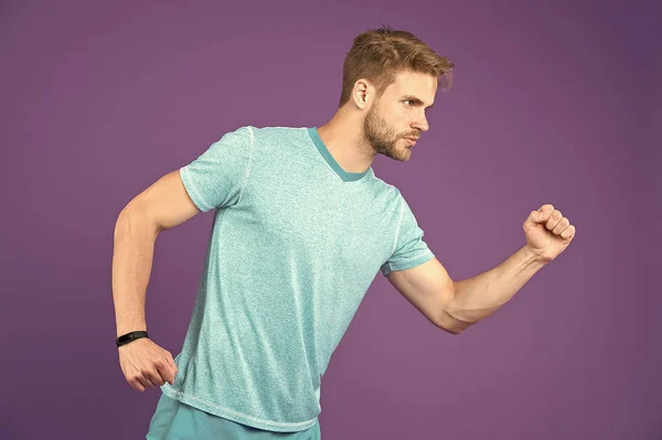 Hombre de camiseta y pantalones cortos sobre fondo violeta. Corredor en ropa casual azul sobre fondo púrpura. Deportista en ropa activa para correr. Estilo y tendencia de la moda deportiva. Actividad física y gimnasia — Foto de Stock