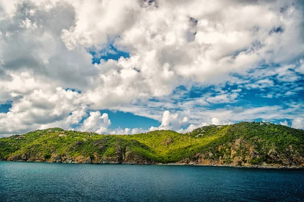 Vuoristoranta sinisellä merellä pilvisellä taivaalla Gustaviassa, st.barts. Kesäloma trooppisella saarella. Villi luonto ja ympäristö, ekologia. Lomakohde ja matkustaa kauniissa maisemassa — kuvapankkivalokuva