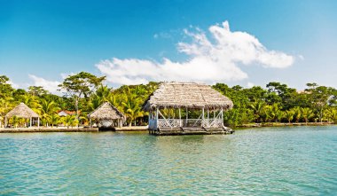 Kulübe Guatemala, santo tomas deniz kıyısında. Evlerin ahşap ve tropikal mavi gökyüzü güneşli kumsalda çimlere. Adada tatil yaz. Yolculuk tutkusu, macera ve keşif