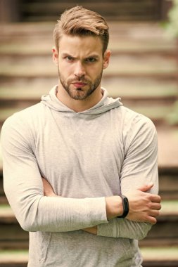 Yakışıklı tarzı. Adam tıraşsız katlanmış silah yakışıklı ve serin görünüyor. Adam görünümü hakkında çekici umurunda sakallı. Adam defocused ciddi bir yüz, kentsel arka plan, kıl. Metroseksüel kavramı