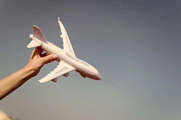 Αεροπλάνο μοντέλο στο χέρι. Αεροπλάνο στο μπλε του ουρανού. Jet ή αεροπλάνο παιχνίδι σε ηλιόλουστο εξωτερική. Ταξιδεύουν με αεροπορικές μεταφορές, αεροπορίας. Σύμβολο της περιπλάνησης, ταξίδι και διακοπές. Όνειρο και φαντασία έννοια, αντίγραφο χώρου — Φωτογραφία Αρχείου