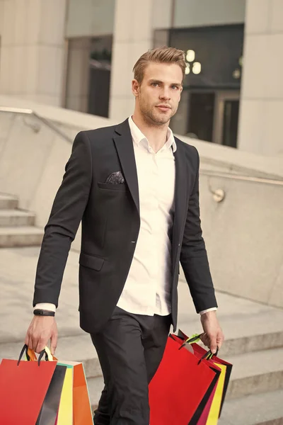 Man stylist professional shopper. Clothes courier. Stylist buy fashionable clothes client. Man formal suit shopping mall. Shop assistant helps carries bunch shopping bags. Shopping service concept