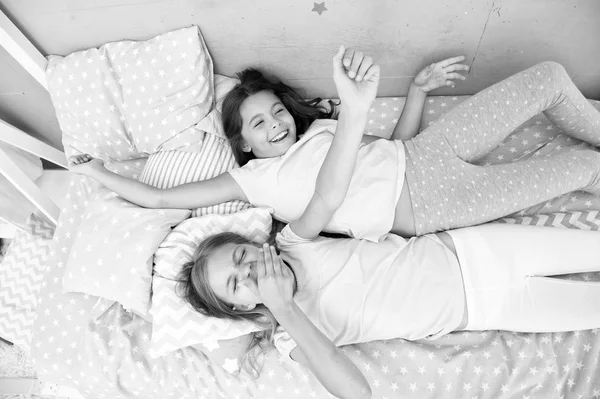 Dzieci dziewczyny leżał na łóżku z poduszki ładny widok z góry. Koncepcji party piżamy. Dziewczyny mają zabawy. Dziewczęcy tajemnic, uczciwy i szczery. Przyjaciele grymasy zabawny wesoły nastrój zabawy. Najlepsi przyjaciele na zawsze — Zdjęcie stockowe