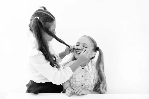 Las chicas hacen bigote con el pelo largo. Imaginemos que eras un niño. Chica alegre humor juguetón jugar con el pelo como bigote. Concepto de masculinidad y feminidad. Moda de peinado. Colegialas uniformes ordenados — Foto de Stock