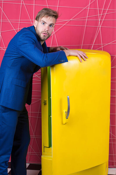 Мужская формальная мода. уверенный бизнесмен в костюме. сексуальный мужчина в стильной куртке. Бизнесмен. Серьёзный человек. Почувствуй успех. Человек стоит рядом с ретро-желтым холодильником. Голод и аппетит