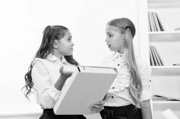 Małe dziewczynki wracają do szkoły w klasie edukacyjnej. Dziewczyny rozwiązują problem podczas zajęć edukacyjnych i szkoleniowych. małe dziewczynki z folderem. — Zdjęcie stockowe