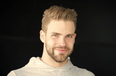 Gülen yüz, siyah arka plan üzerinde kıl olan adam. Metroseksüel kavramı. Sakal veya tıraşsız adam görünüyor yakışıklı ve sağlıklı bir cilt ile serin adam. Adam sakallı ve çekici görünümü ile ilgili umurunda değil.